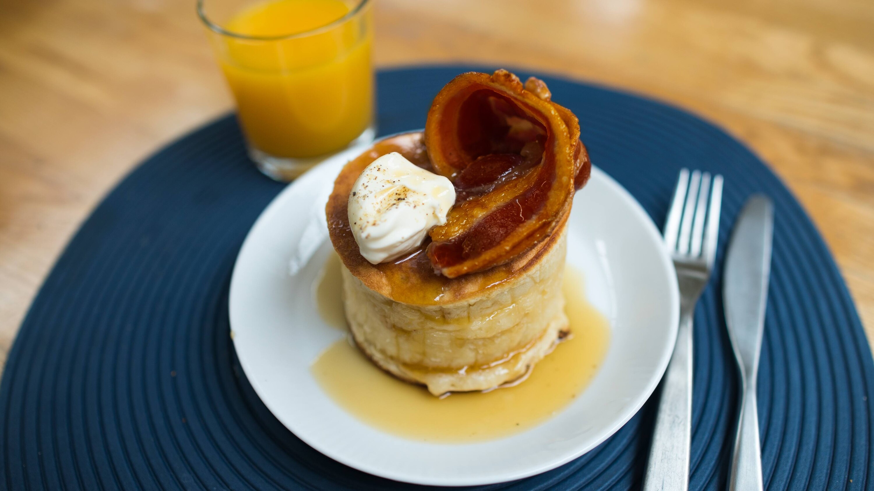 Fluffy pancake tower with bacon and maple syrup