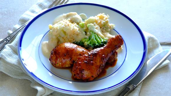 Spicy roasted drumsticks with cheesy cauliflower and broccoli bake