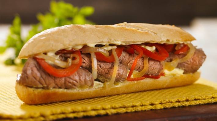 Sandwich tibio de carne, cebolla, morrones y queso con salsa...
