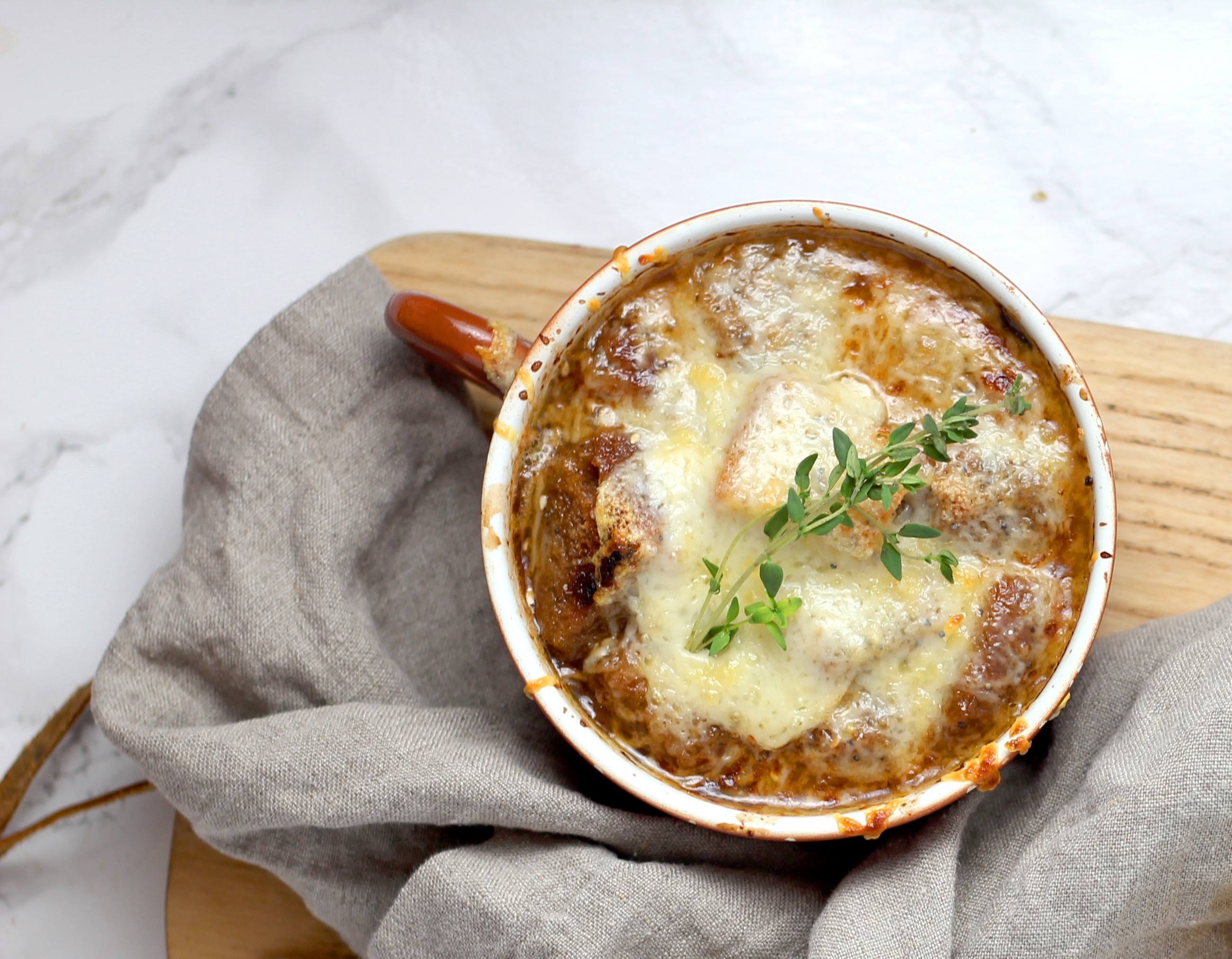 Rich and flavorful french onion soup inside a white soup bowl
