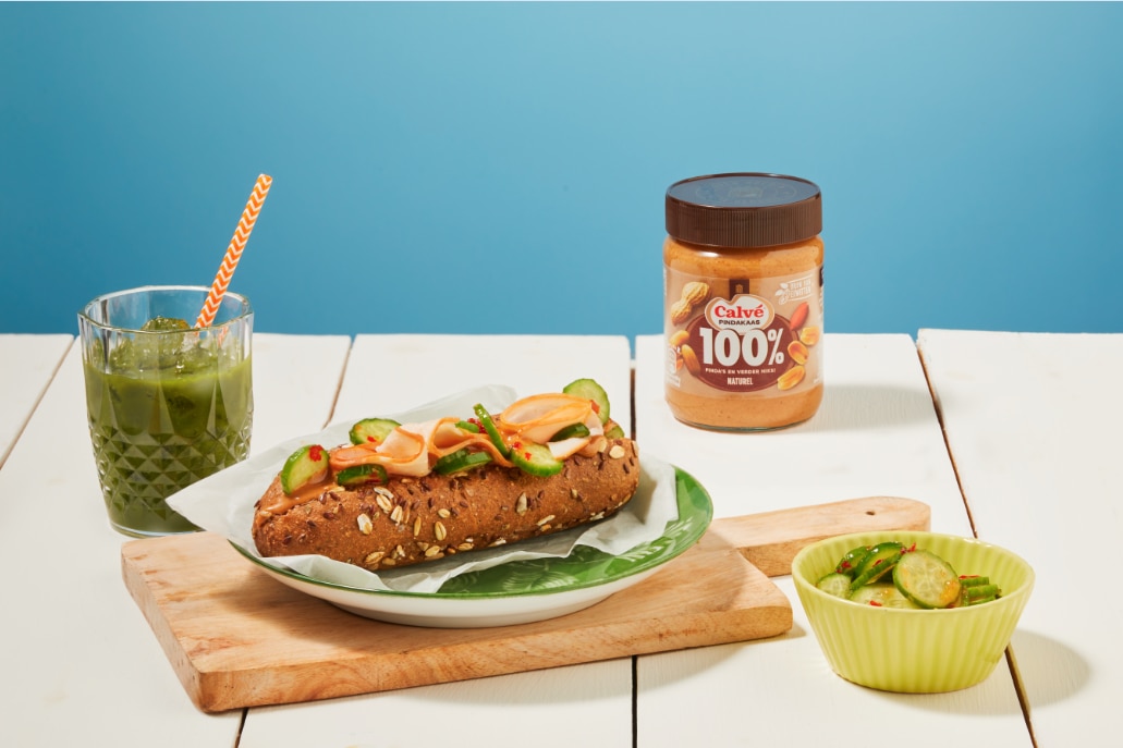 Volkoren broodje met 100% pindakaas, gerookte kipfilet en pittige komkommer