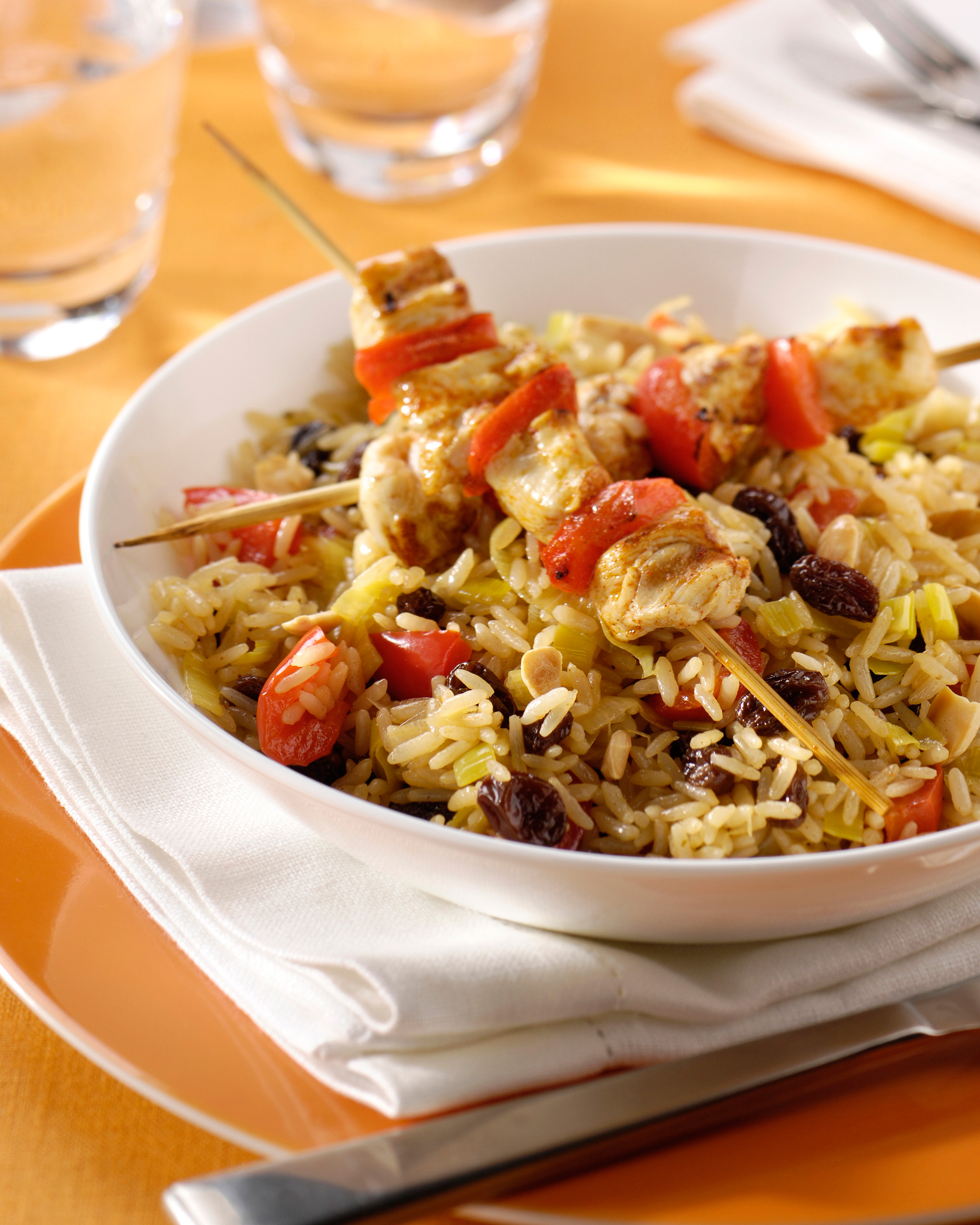 Riz aromatique aux raisins secs et aux amandes, brochettes de poule