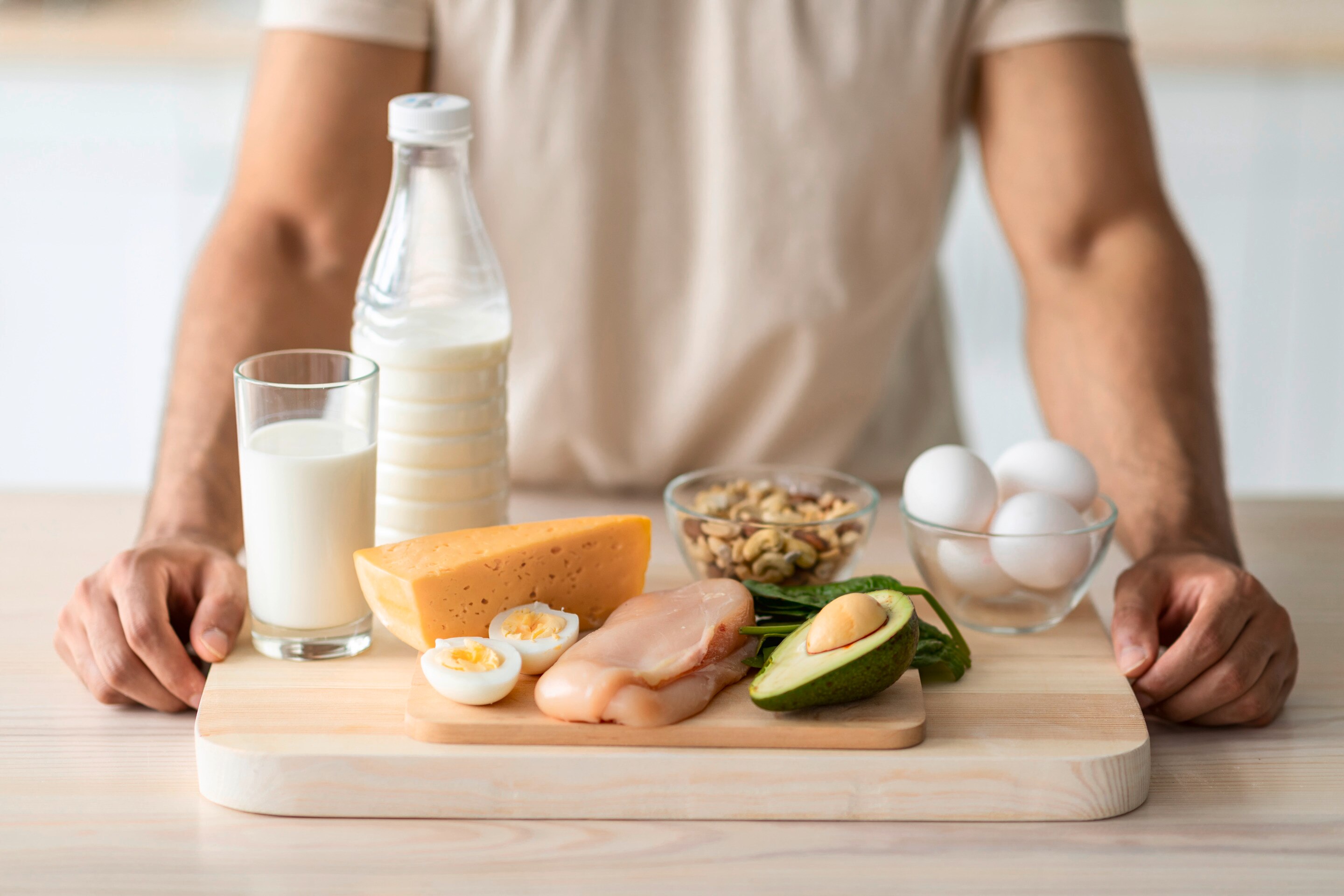 A man with a cutting board of healthy post-workout meal ingredients. 