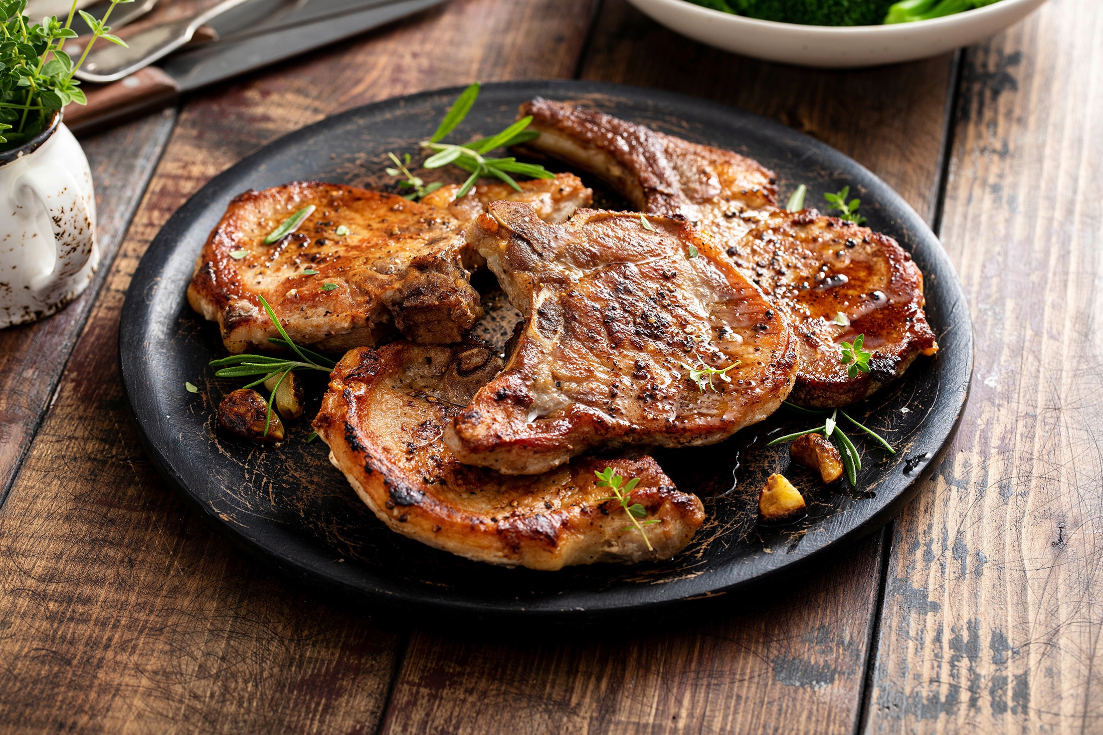  A plate of grilled pork chops garnished with fresh herbs