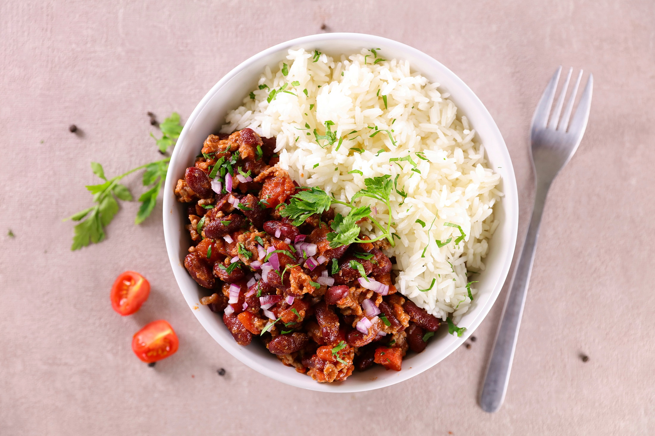 A chili con carne rice bowl on a gray tabletop