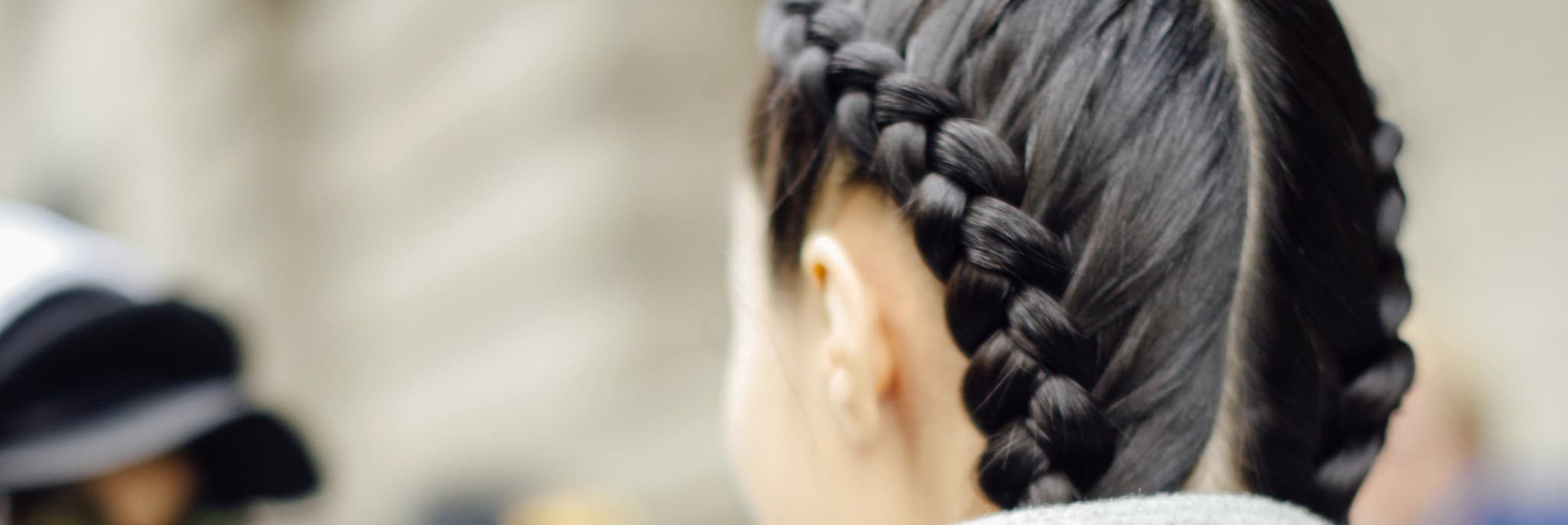 A model with dark brown hair in two thick braids 