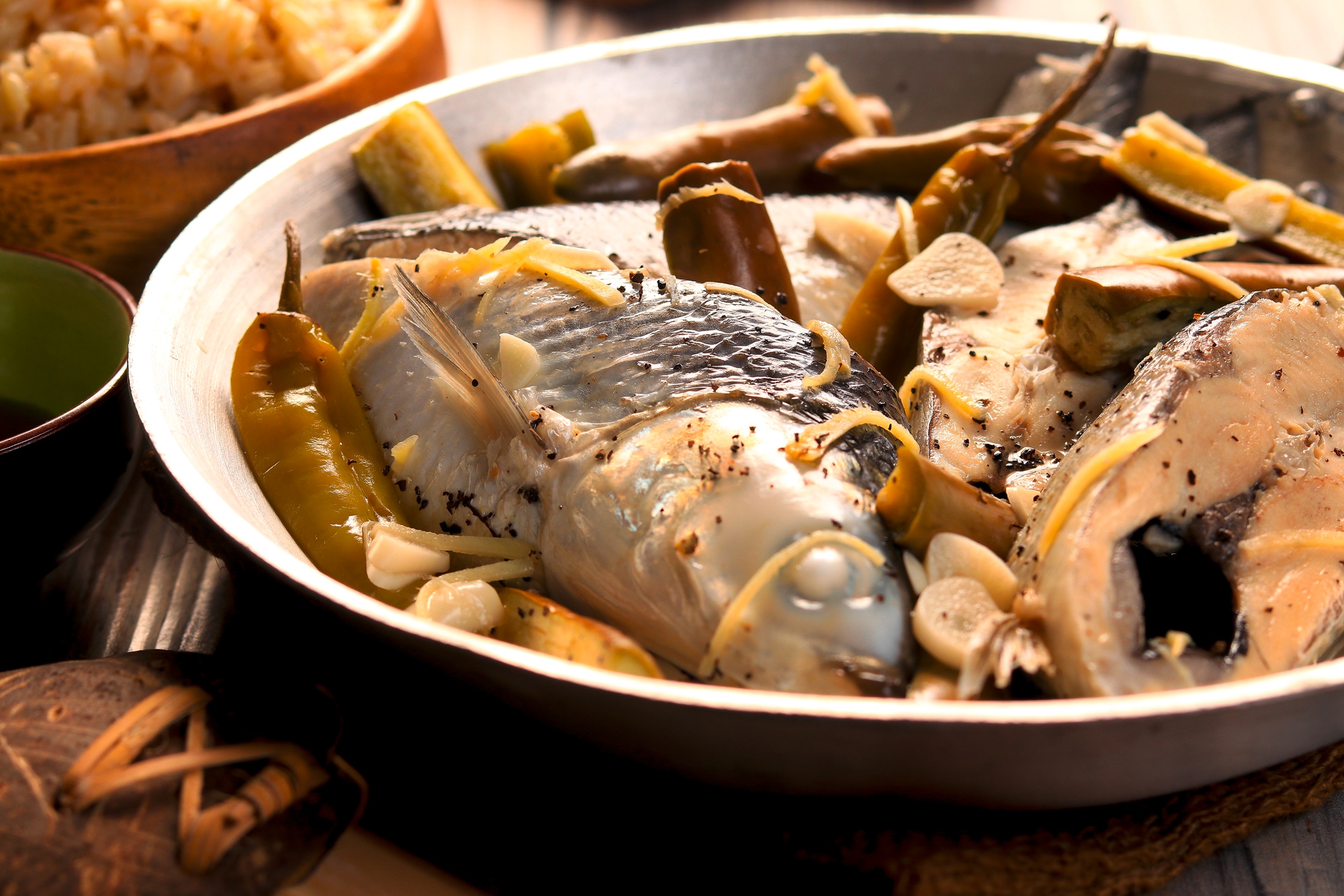 A pan of freshly cooked fish paksiw with chilies and eggplants