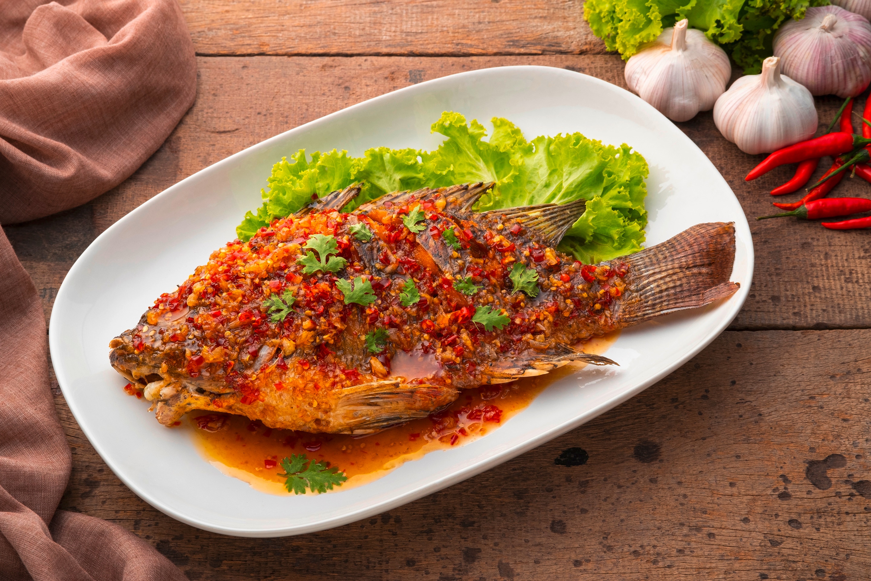 A serving of roasted tilapia topped with a sweet and sour sauce