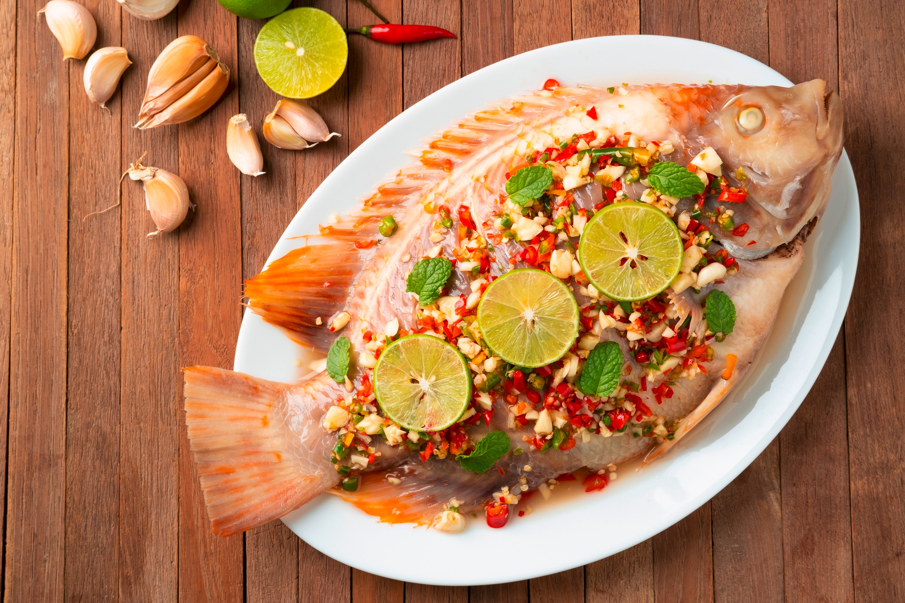 Try steaming your tilapia with garlic, chilies, citrus, and herbs