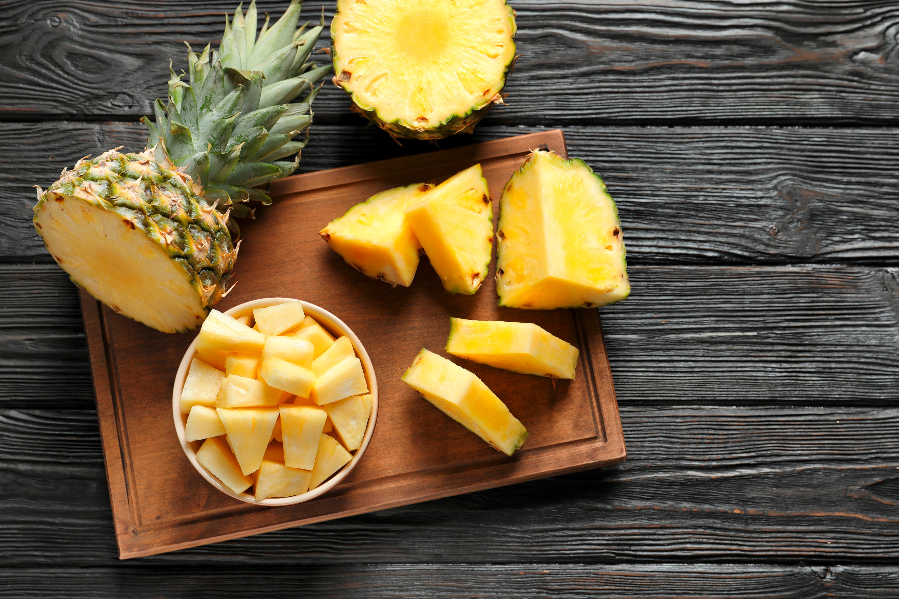 Fresh pineapples on a wooden tray