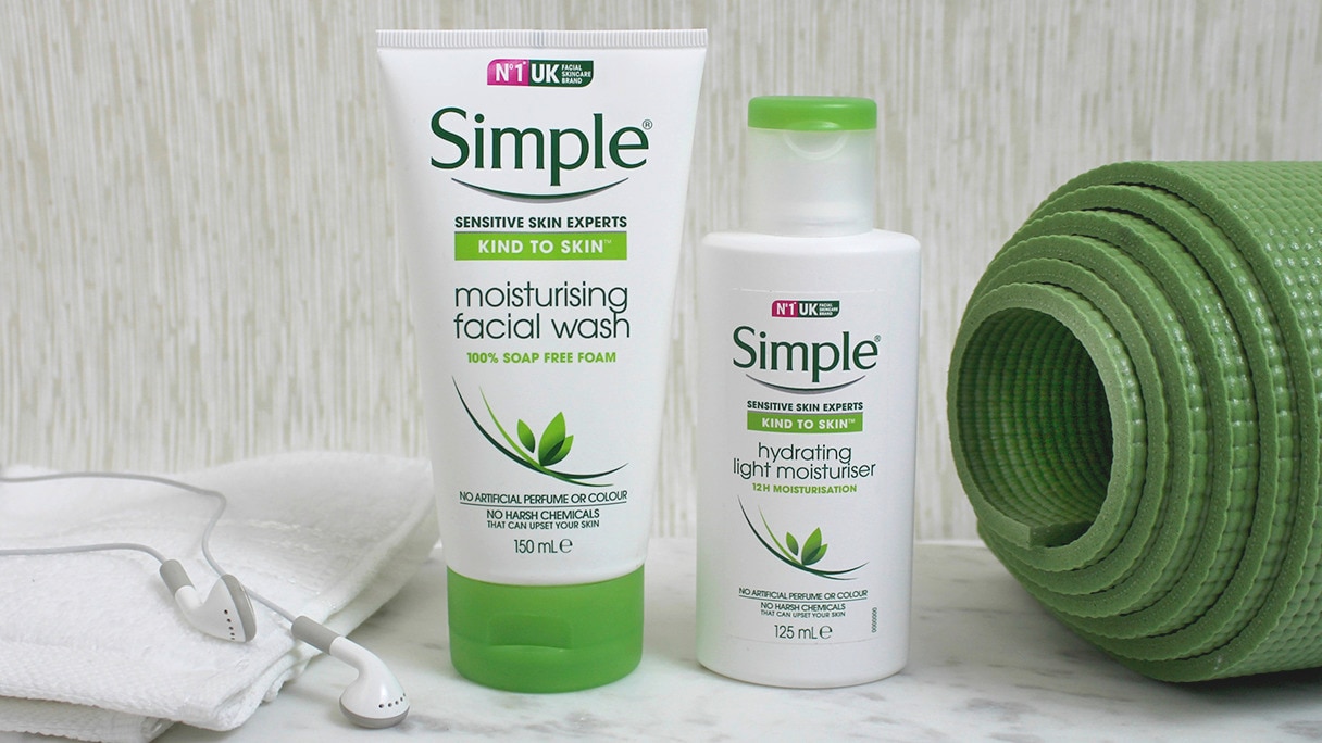 ซิมเพิล มอยส์เจอร์ไรซิ่ง เฟเชียล วอช และไฮเดรติ้ง ไลท์ มอยซ์เจอร์ไรเซอร์ วางคู่กับเสื่อโยคะสีเขียวและเฮดโฟน 