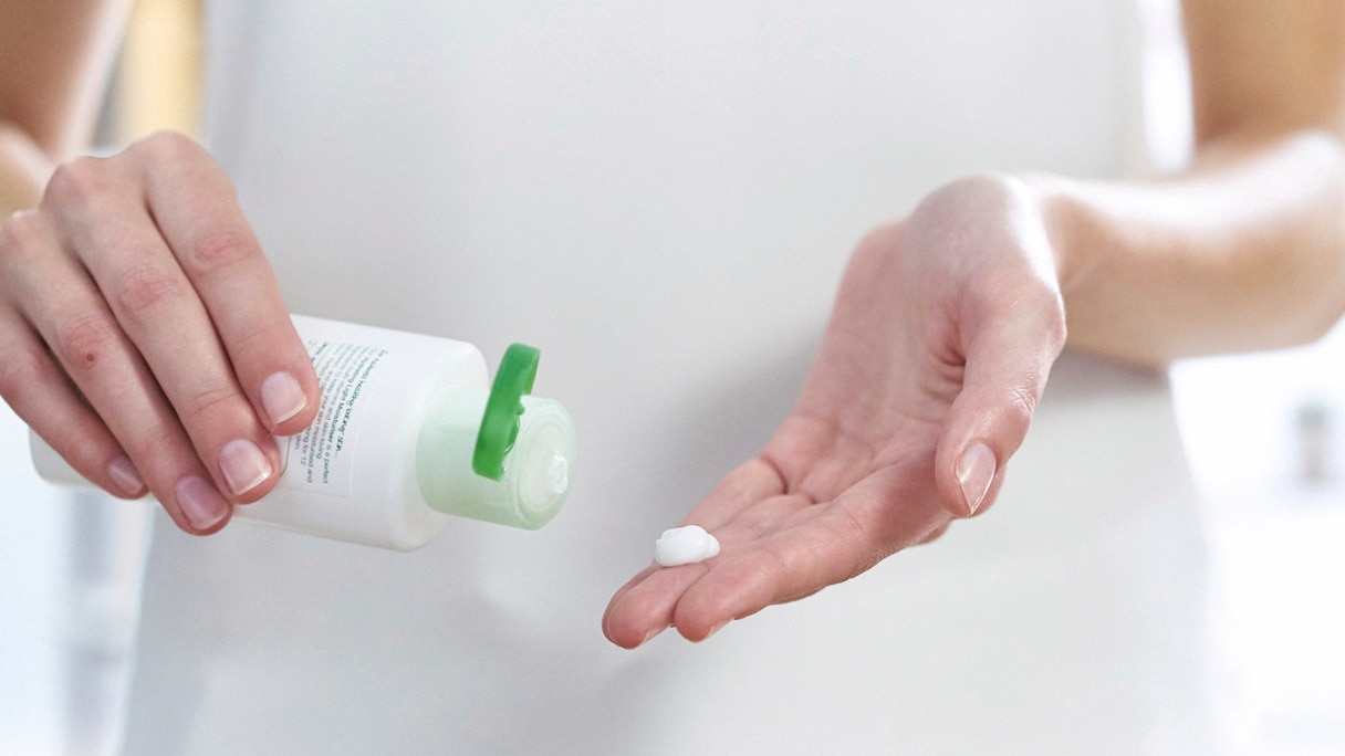 Woman squeezing Simple moisturiser into her hand