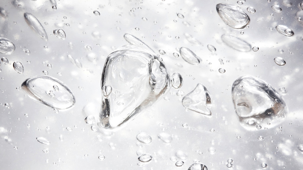 A close-up of water droplets on a grey background