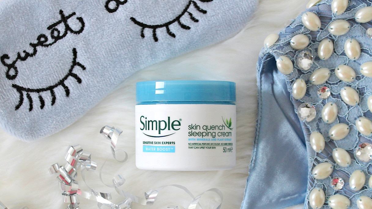 Tub of Simple Skin Quench Sleeping Cream with blue eye mask on a fluffy white background