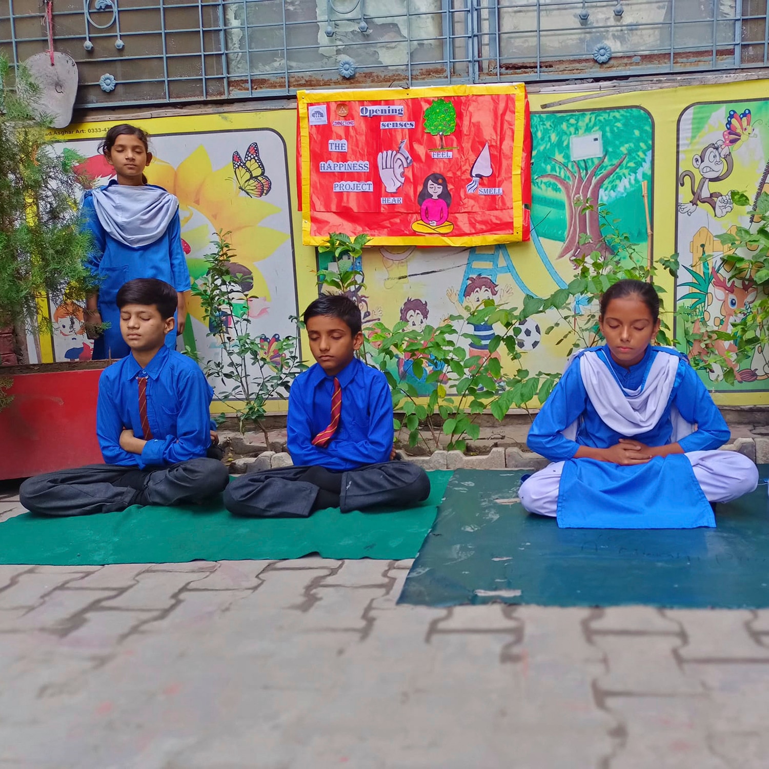 fyra unga studenter som sitter på marken och gör en meditationssession