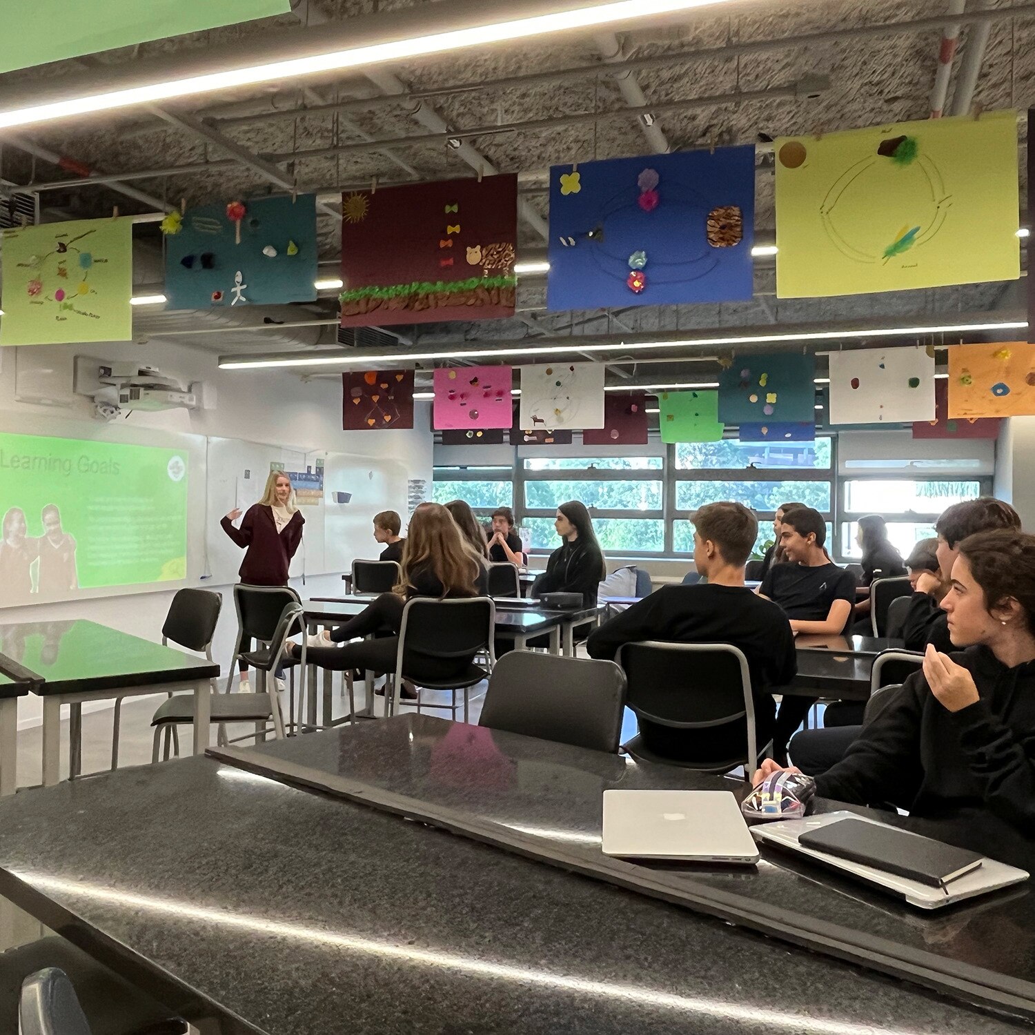 en elev som undervisar en klass om lycka för sina klasskamrater i ett modernt klassrum