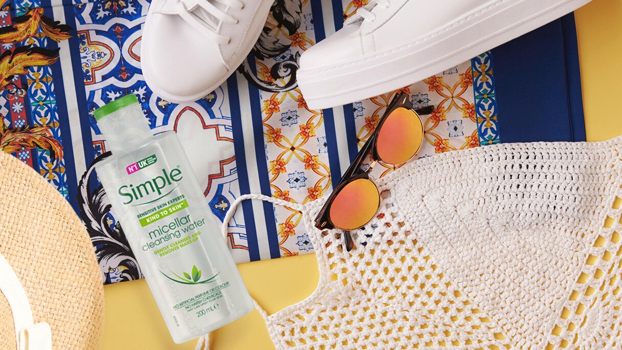 Flatlay of Simple Micellar Cleansing Water with sneakers, hat and sunglasses