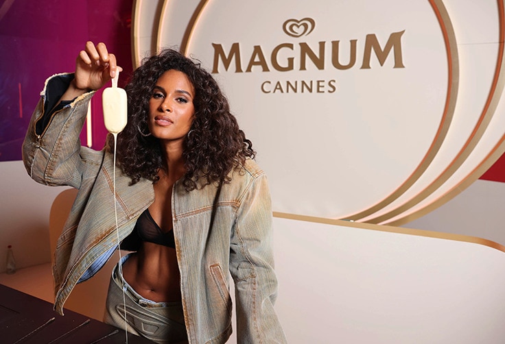Cindy Bruna holding an upside down magnum, white chocolate dripping