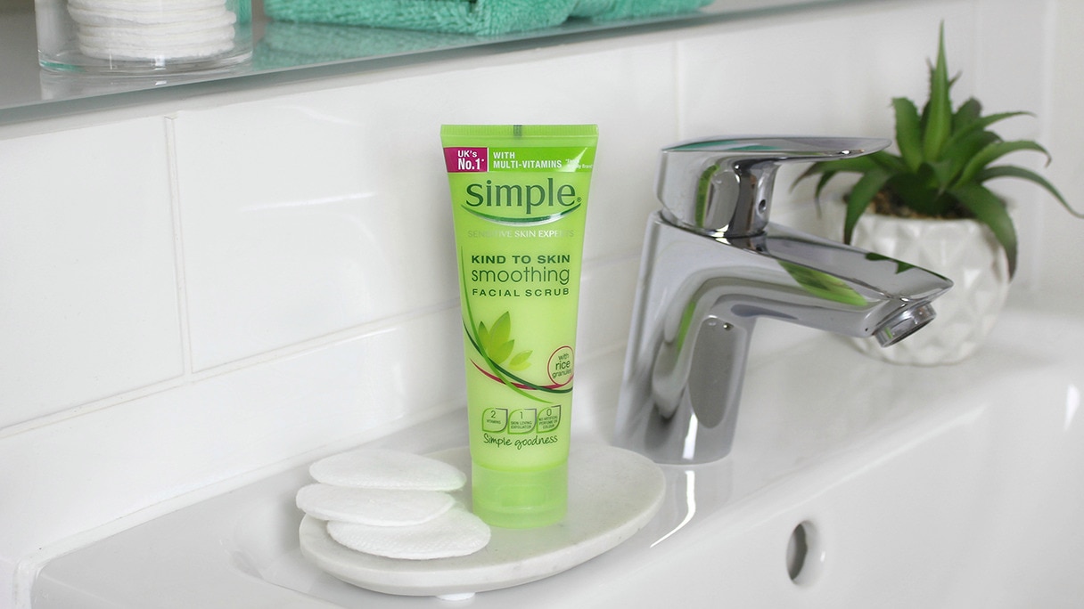 Bottle of Simple Soothing Facial scrub sitting on a bathroom sink