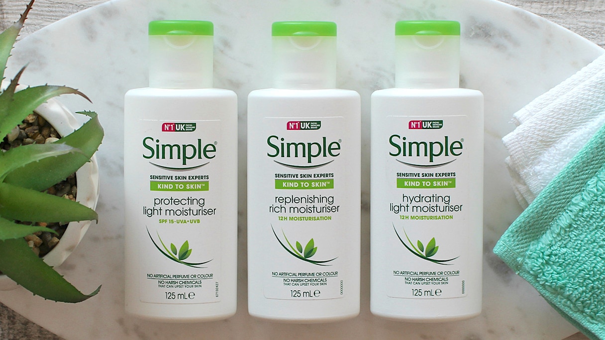 Flatlay of three Simple moisturisers with make-up brushes on a green and white background