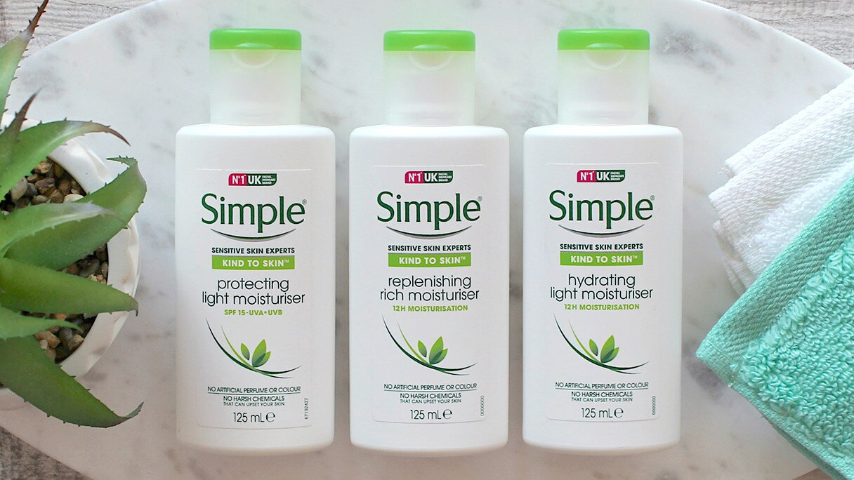 Three Simple moisturisers on a marble board alongside a pot plant and face cloth