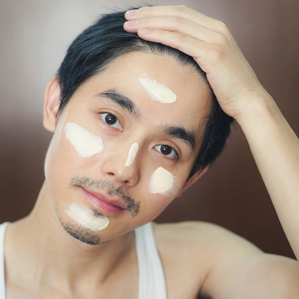 Handsome man using facial toners for even skin