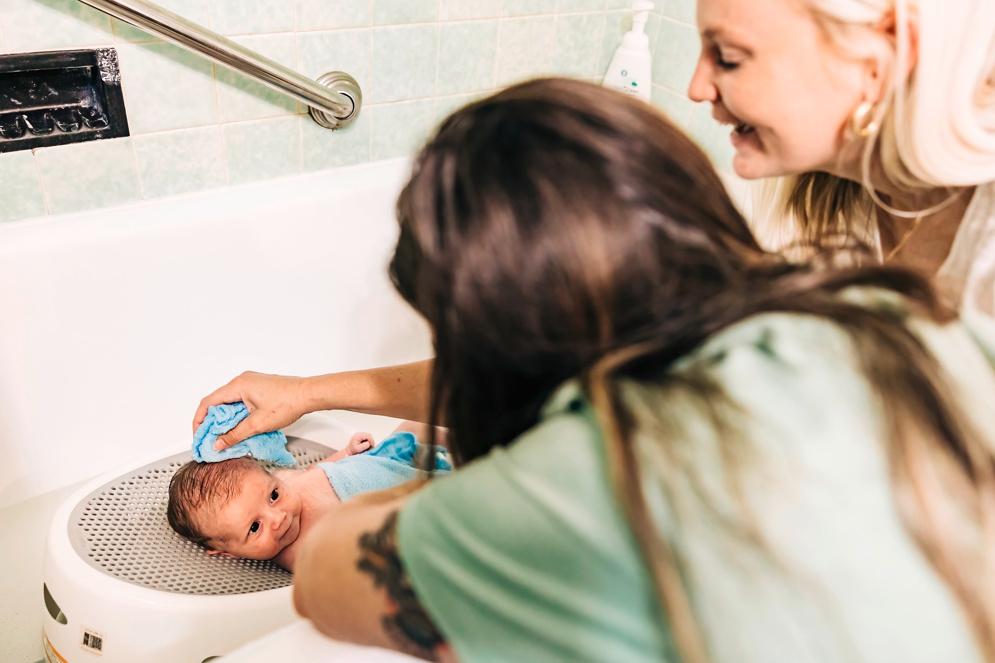 Baby smiling at parent whilst having a bath