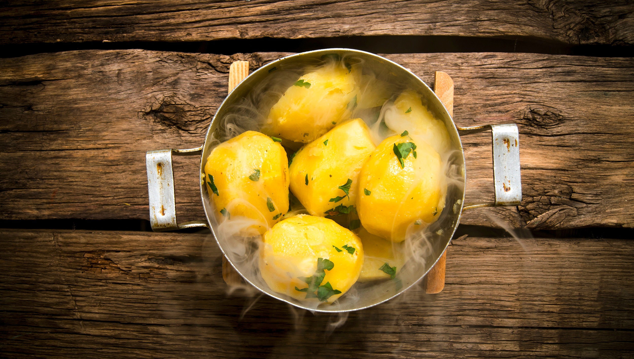fertig gekochte Kartoffeln dampfend im Topf