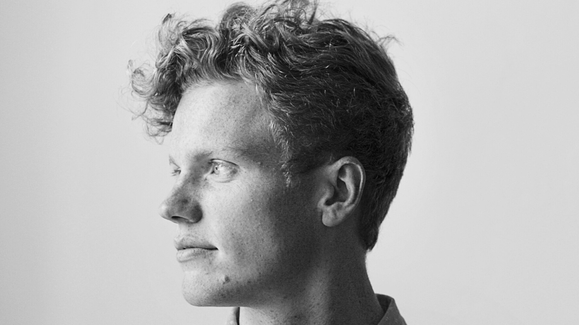 Un hombre con pecas, pasando sus manos por el pelo.