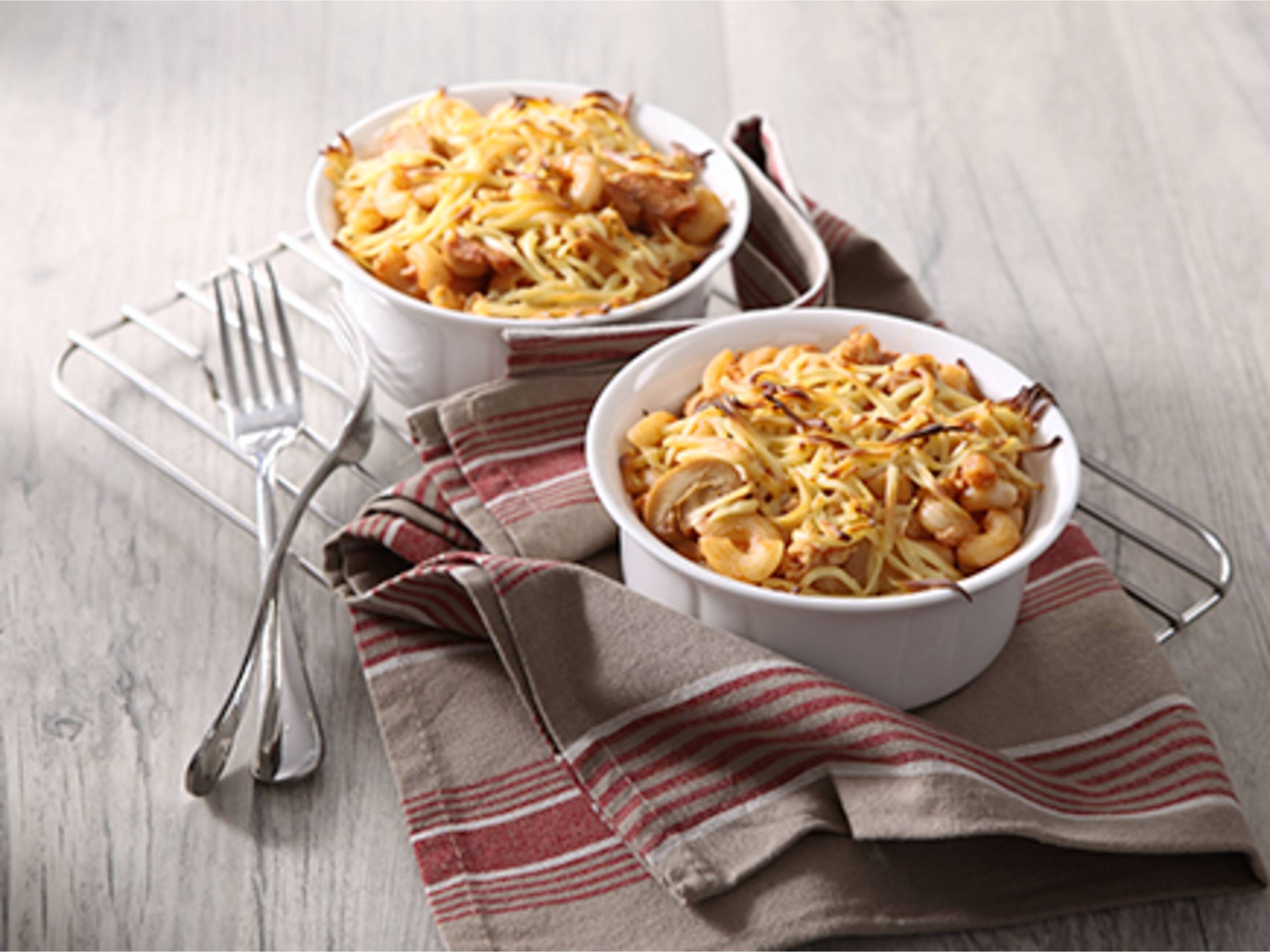 Two ramekins with cheesy baked macaroni served hot out of the oven