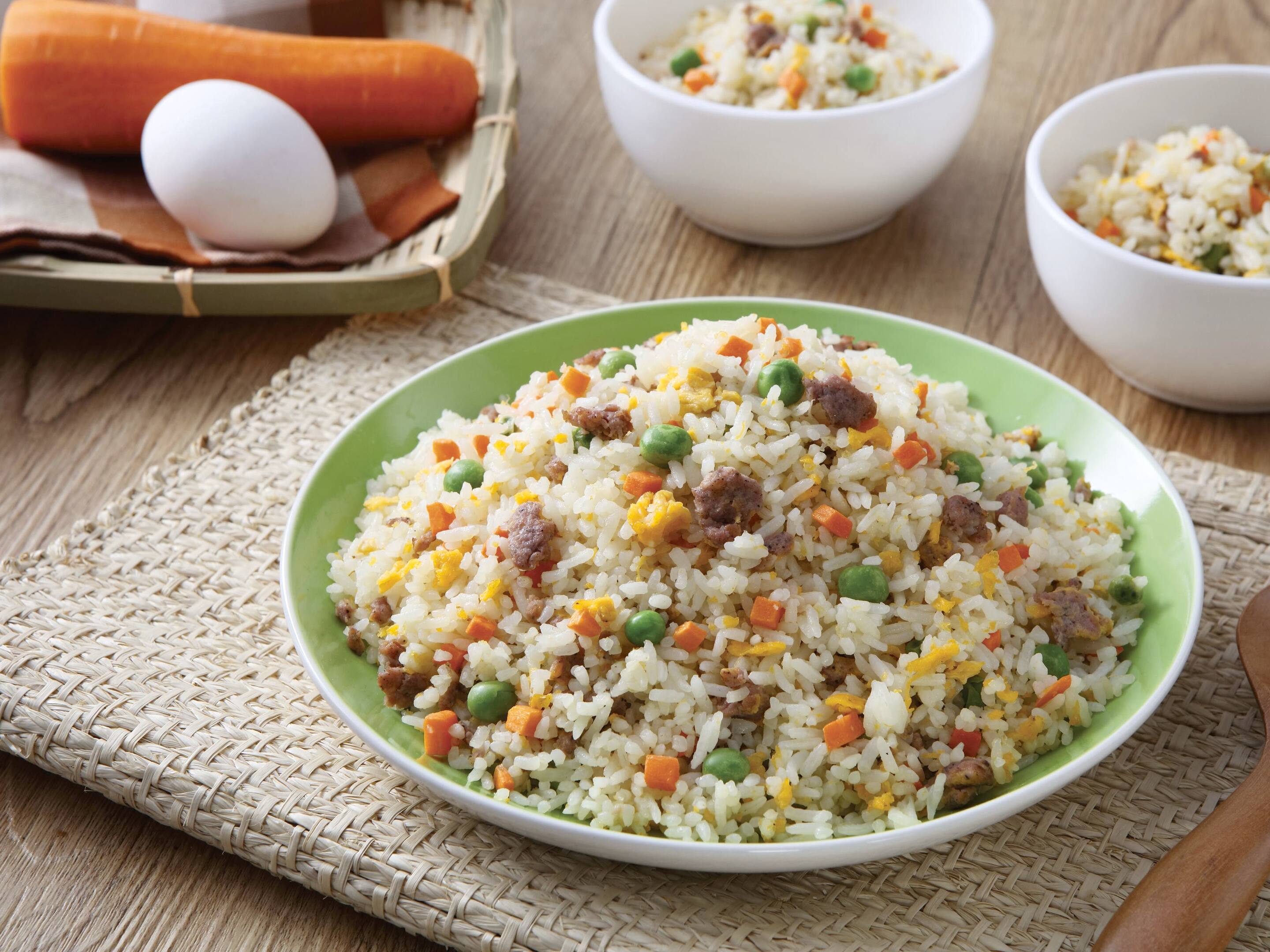A plate of skinless longganisa fried rice with green peas, chopped carrots, and scrambled eggs