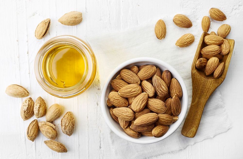 Bowl of almonds and almond oil.