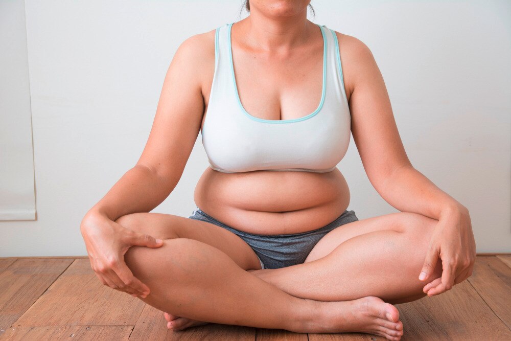 Asian woman sitting cross-legged on the floor.