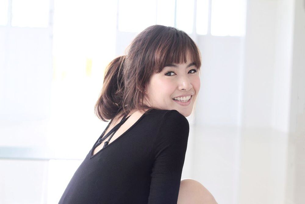 Asian woman looking back and smiling.