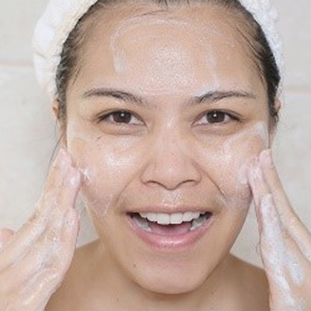 A beautiful woman doing her facial to target uneven skin tone on her face
