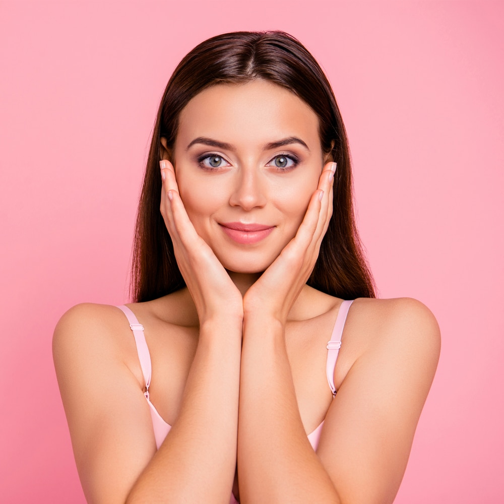 A beautiful woman holding her face to hide blackheads, dark spots and blemishes