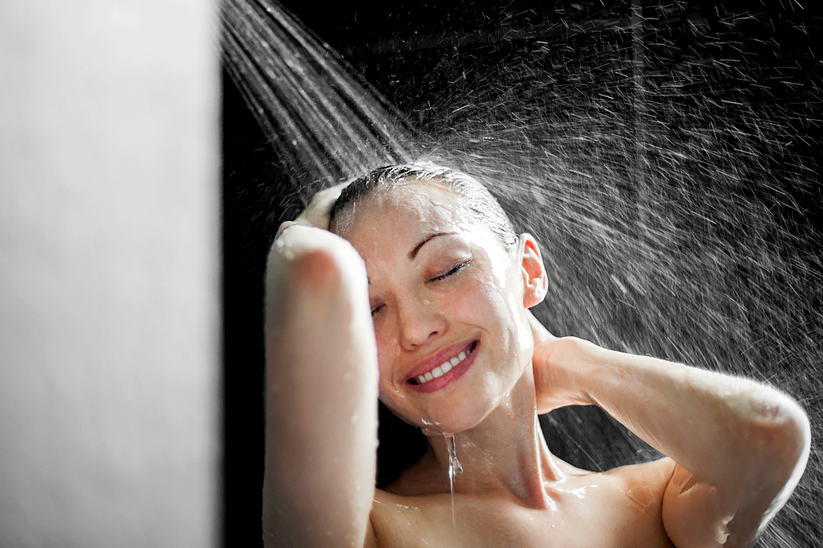 Smiling woman enjoying a shower.