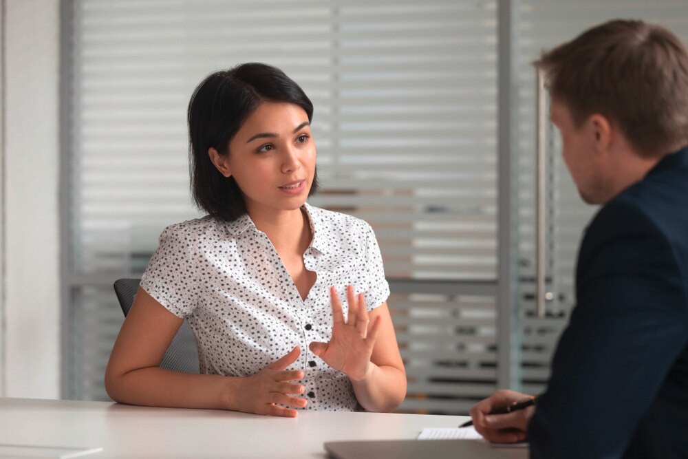 Asian woman talking to a man at the office.