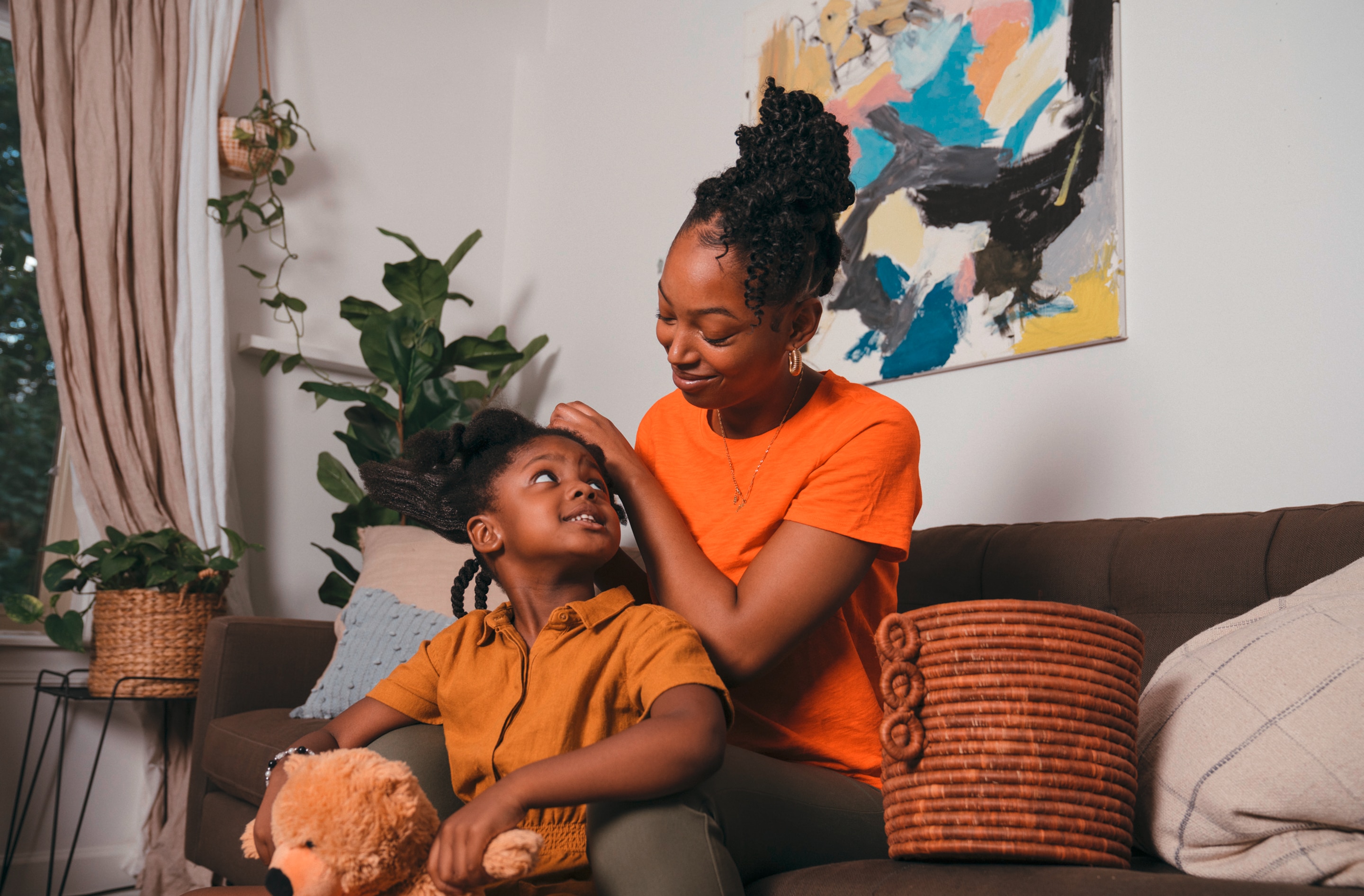 Black mother doing her daughter's hair