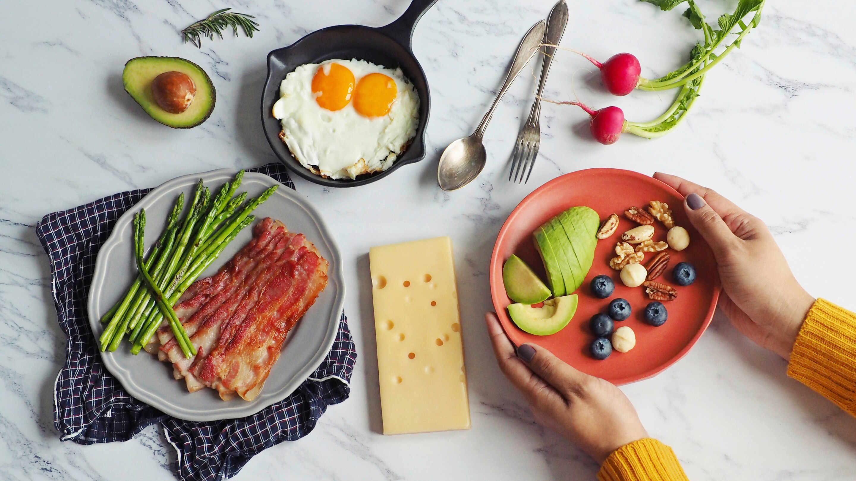 Woman serving avocadoes and berries for breakfast.