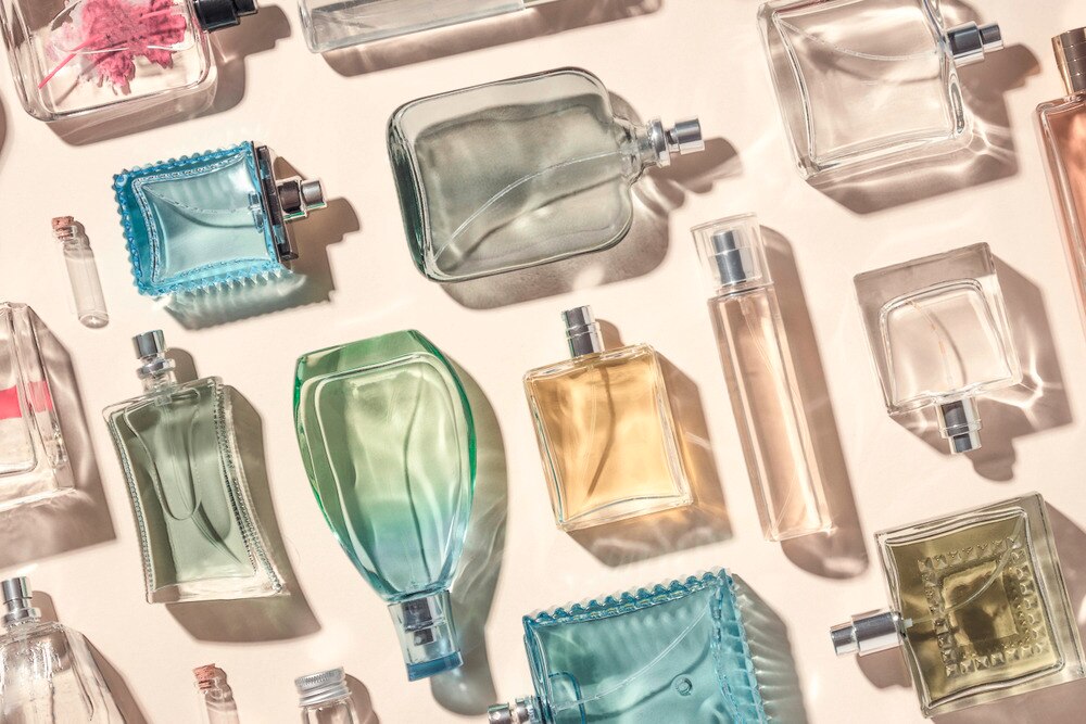 An array of perfume bottles lying flat on a white surface.