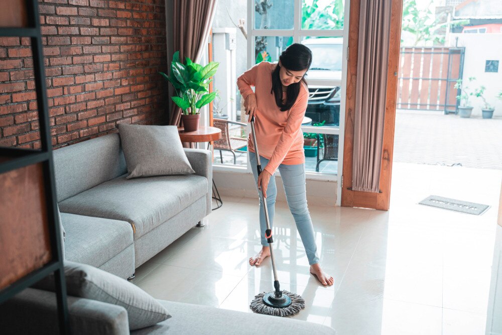 Asian woman mopping the floor.