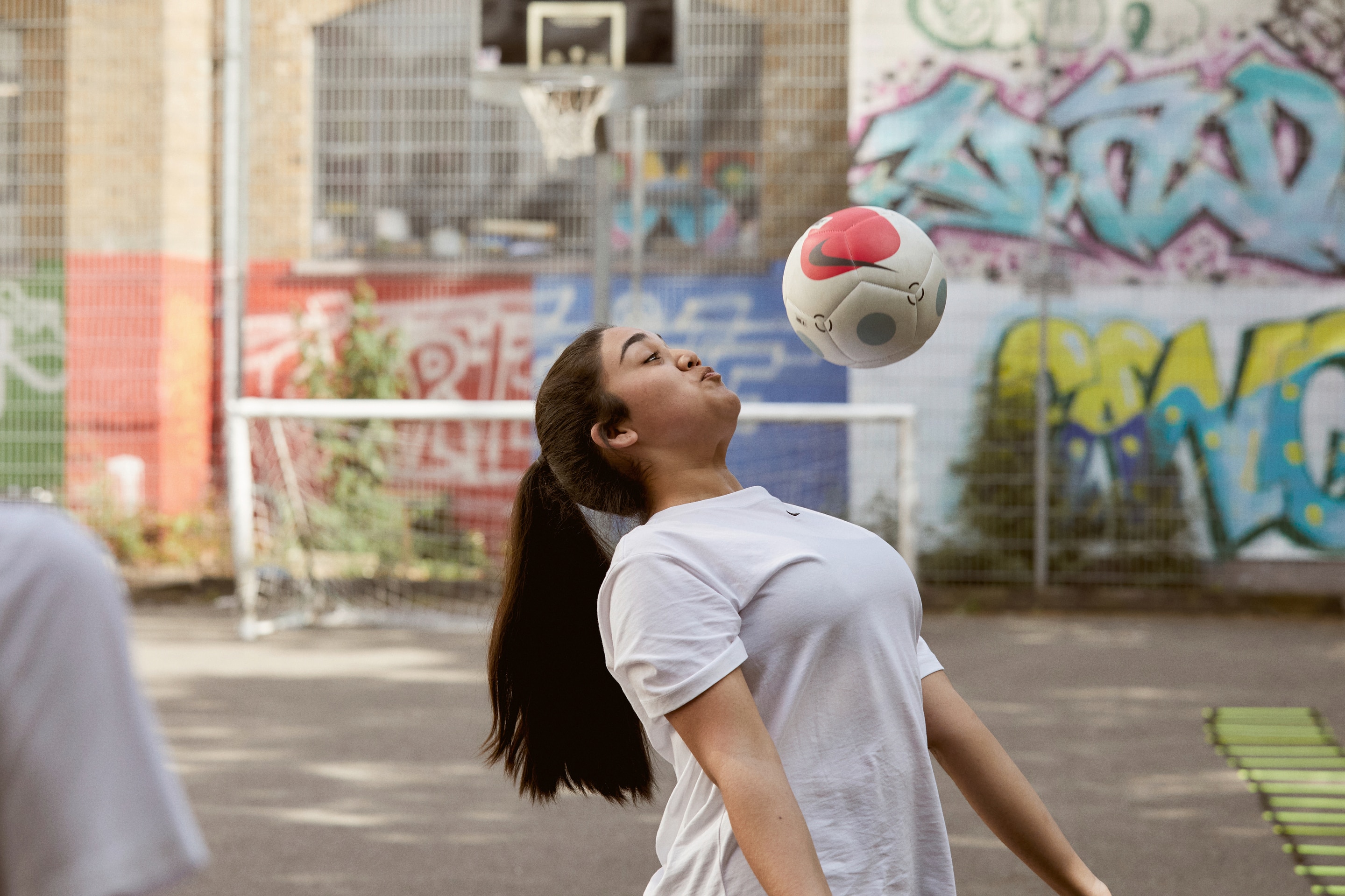 Girl in TikTok phone frame doing a soccer trick