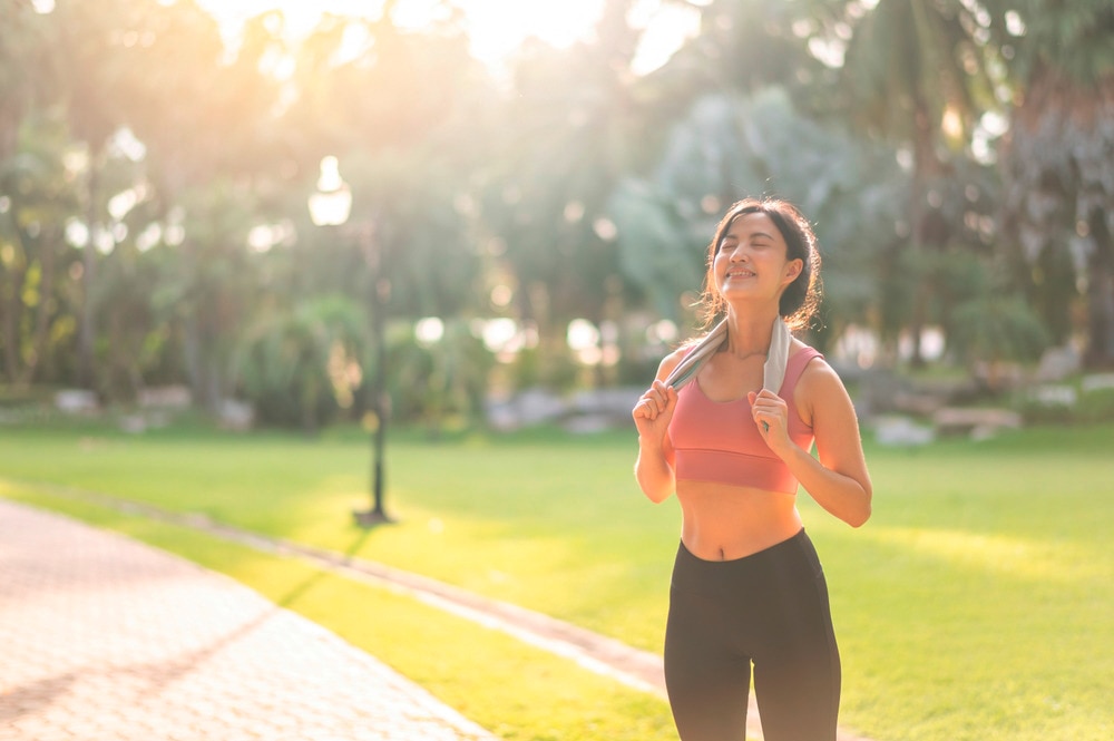 Asian female ecstatic after an outdoor workout.