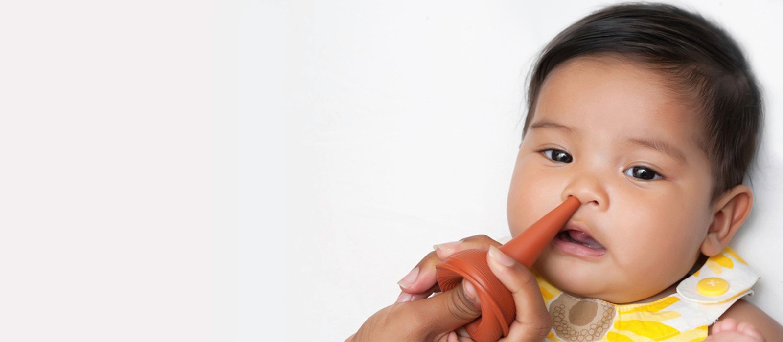 seorang bayi laki-laki sedang menggunakan nasa aspirator pada hidungnya