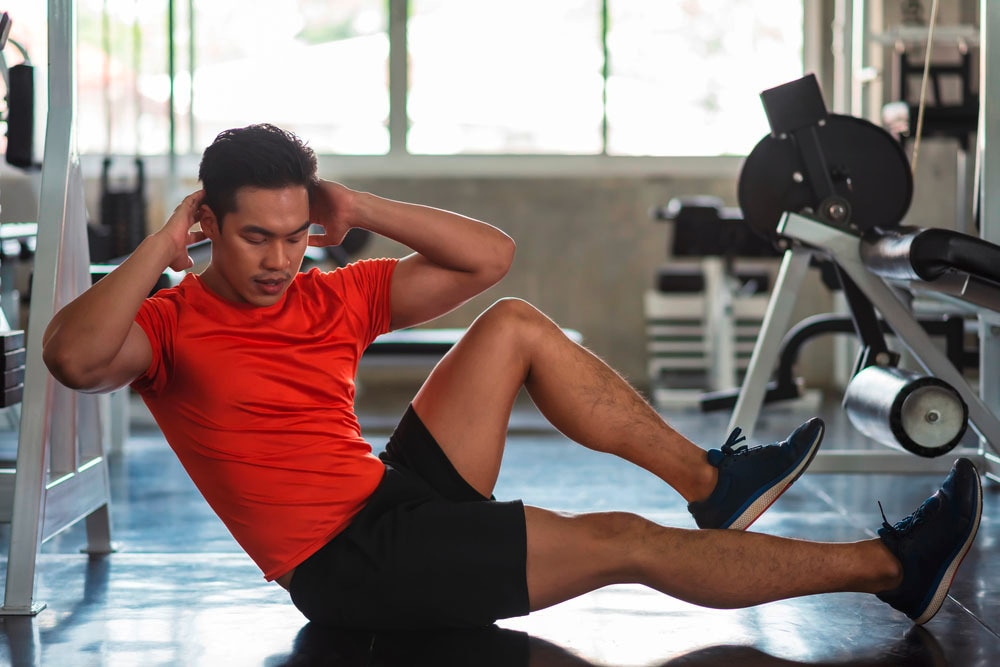 Man doing bicycle crunches at the gym.
