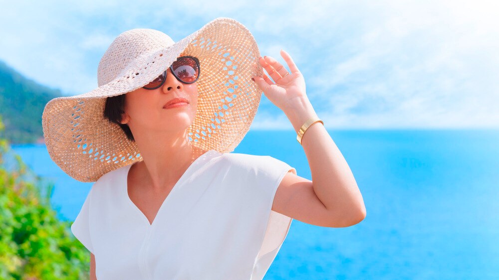 A portrait of woman with sunhat and glasses.