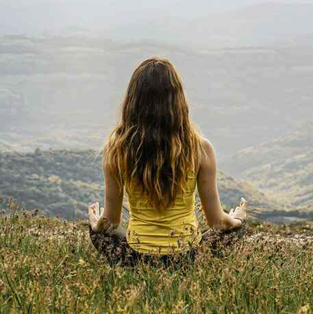 girl meditating on the mountains