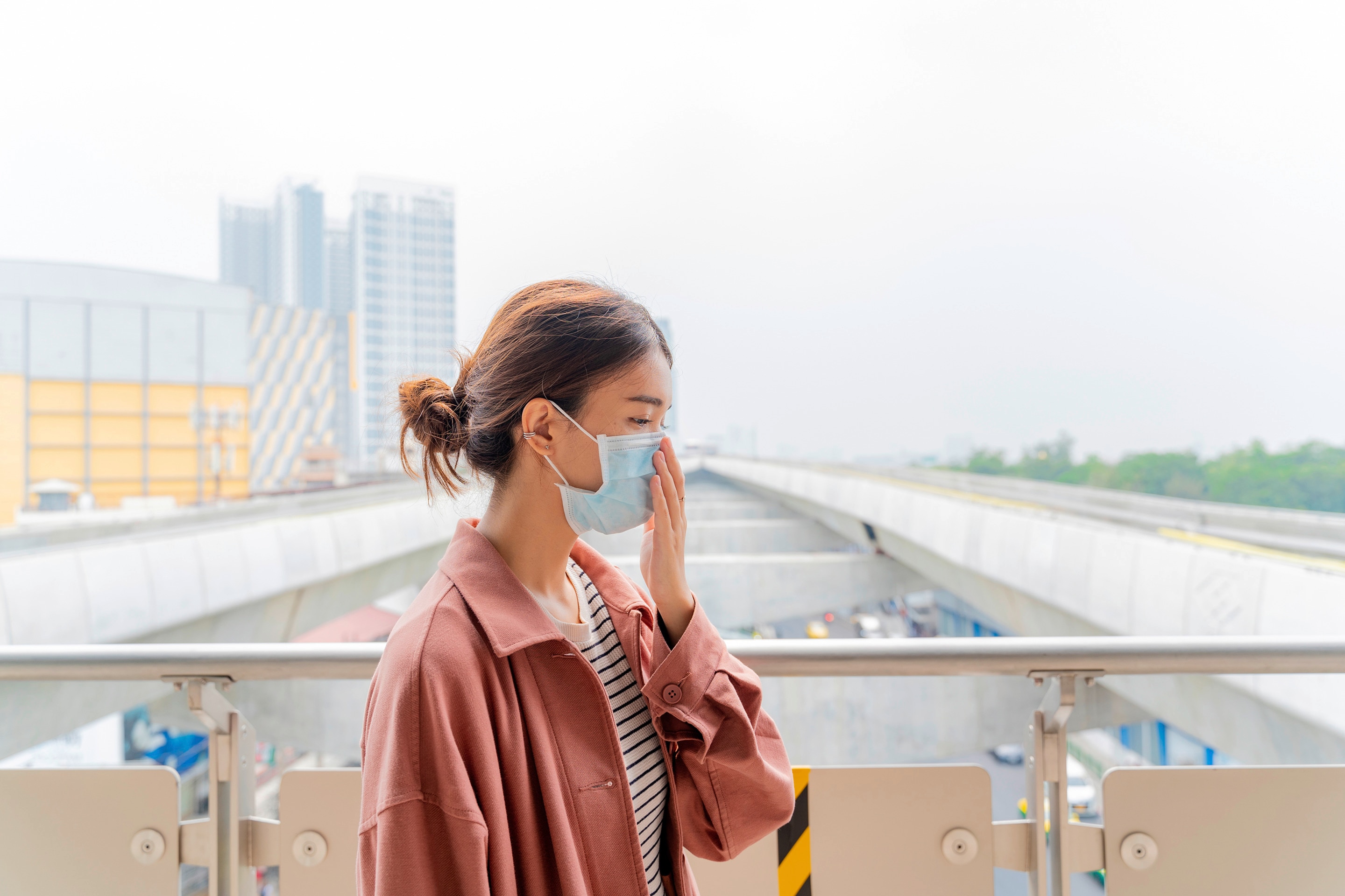 Asian woman with surgical mask outdoors 