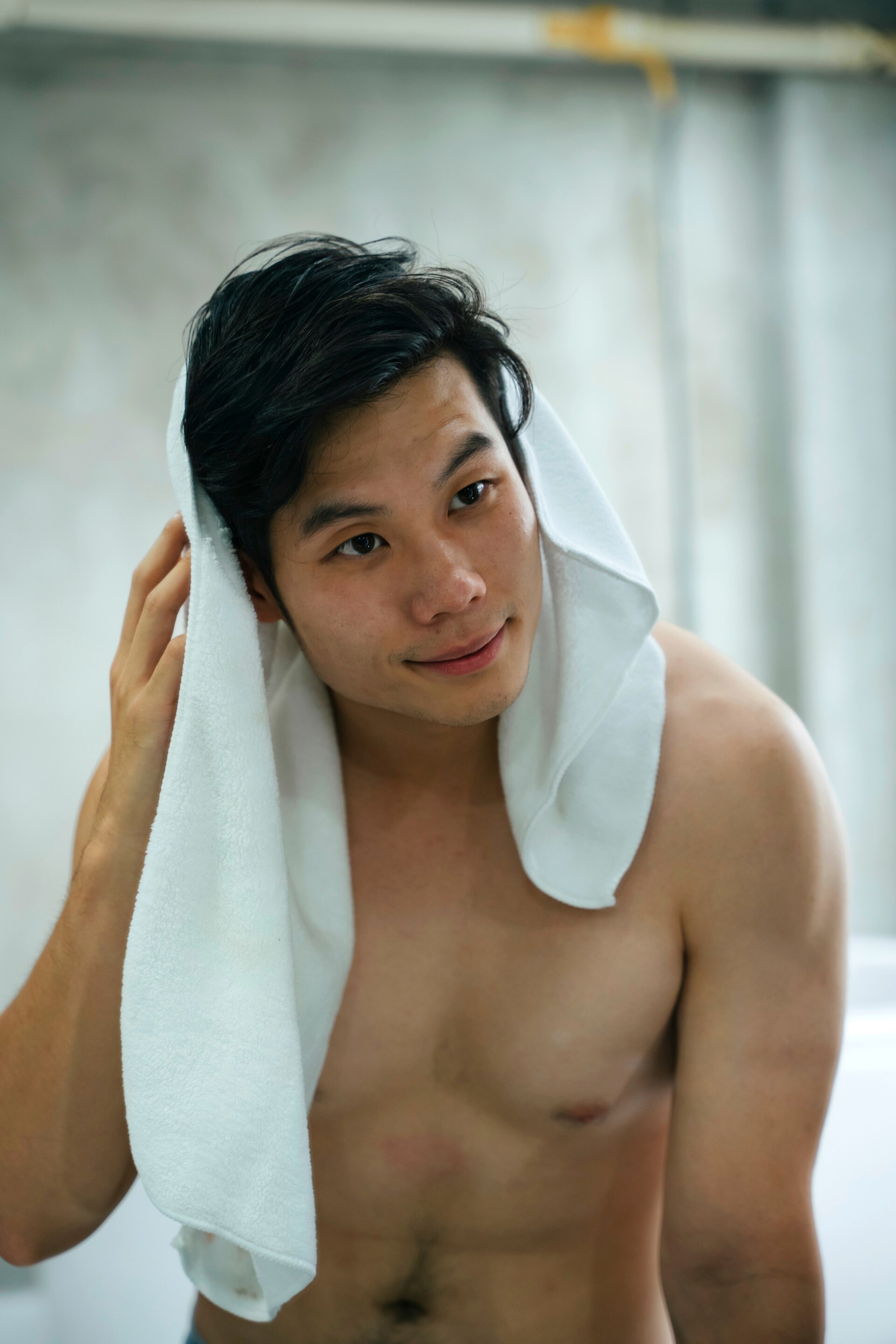 A man drying his hair after taking a shower